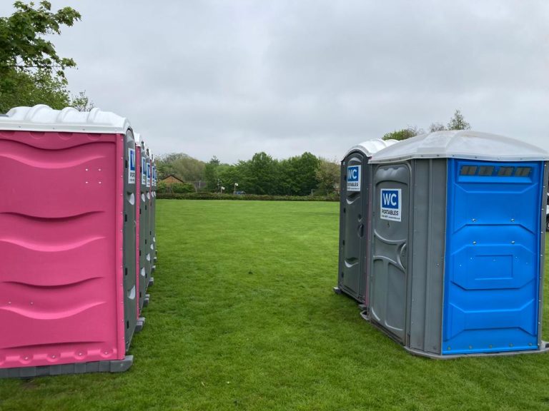 pink and blue portable toilets on the field